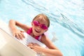 Cheerful little girl using laptop in swimming pool Royalty Free Stock Photo