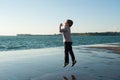 Cheerful little kid jumping on the background of sea port