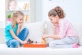 Cheerful little sisters sitting on the sofa