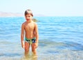 Cheerful llittle boy enjoy play with water on beach.
