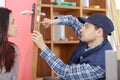 Cheerful locksmith installing door lock under clients surveillance Royalty Free Stock Photo