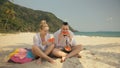 The cheerful love couple holding and eating slices of watermelon on tropical sand beach sea. Romantic lovers two people Royalty Free Stock Photo