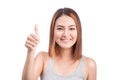 Cheerful lovely girl looking at camera showing thumbs up over white background.