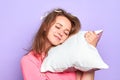 Cheerful lovely girl rests on pillow with happy smile, sees pleasant dreams