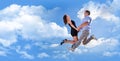 Cheerful loving couple in a jump against the blue sky