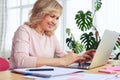 Cheerful madam smiling and printing in laptop Royalty Free Stock Photo