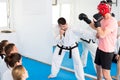 Coach explaining painful hold in taekwondo class