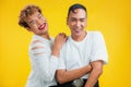 Cheerful male couple smiling on yellow background. Two asian gay standing together and looking at camera Royalty Free Stock Photo