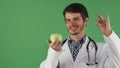 Cheerful male doctor holding vitamin pill and an apple Royalty Free Stock Photo