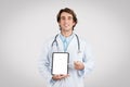 Cheerful male doctor presenting blank tablet screen Royalty Free Stock Photo