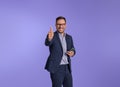 Cheerful male entrepreneur gesturing thumbs up after reading good news over smart phone. Happy young businessman showing perfect Royalty Free Stock Photo