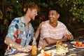 Cheerful male friends laughing during barbeque party