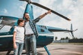 Cheerful male hugging boy on landing field Royalty Free Stock Photo