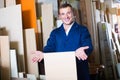 Cheerful male worker standing with plywood pieces Royalty Free Stock Photo