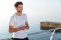 Cheerful man athlete in white t-shirt using cell phone Royalty Free Stock Photo