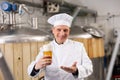 Cheerful man brewer presenting glass of beer Royalty Free Stock Photo