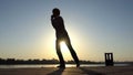 Cheerful man dances jive on a river bank in summer in slo-mo