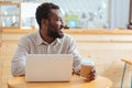 Cheerful man drinking coffee while working on laptop Royalty Free Stock Photo