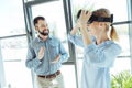 Cheerful man giving applause to colleague removing VR headset Royalty Free Stock Photo