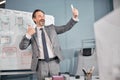 Cheerful man giving thumbs up and making selfie at work Royalty Free Stock Photo