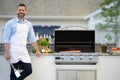 cheerful man grilling salmon fillet at backyard, copy space advertisement.