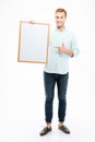 Cheerful man holding blank white board and pointing on it Royalty Free Stock Photo