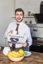 Cheerful man holding business newspaper and coffee cup while looking at camera. Royalty Free Stock Photo