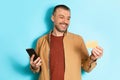 Cheerful Man Holding Credit Card And Phone Over Blue Background Royalty Free Stock Photo