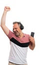 Cheerful man holding phone listening music in headphones dancing Royalty Free Stock Photo