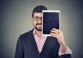 Cheerful man holding a tablet in front of his face Royalty Free Stock Photo