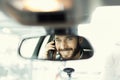 Cheerful man on mobile phone in the car. Reflection in the mirror Royalty Free Stock Photo