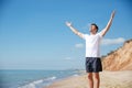 Cheerful man with outstretched arms standing on the beach Royalty Free Stock Photo