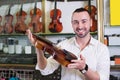 Cheerful man purchasing traditional violins Royalty Free Stock Photo