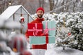 Cheerful man with gift boxes on winter time outdoors