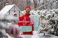 Cheerful man with gift boxes on winter time outdoors