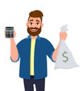 Cheerful man showing or holding digital calculator device and cash, money, currency note bag in hand. Modern lifestyle. Royalty Free Stock Photo