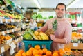 Cheerful man standing with full shopping cart during shopping Royalty Free Stock Photo