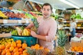 Cheerful man standing with full shopping cart during shopping Royalty Free Stock Photo