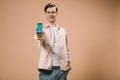 Cheerful man standing with hand in pocket and holding smartphone with twitter app on screen isolated Royalty Free Stock Photo