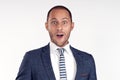 A cheerful man in a suit with a tie is surprised. White background. Isolated image.