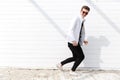 Cheerful man in sunglasses running over white wall background Royalty Free Stock Photo