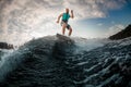 cheerful man wavesurfer having fun and balancing on wakeboard along the river wave