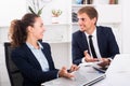 cheerful man and young woman coworkers talking in firm office Royalty Free Stock Photo