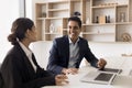 Cheerful manager and client discussing successful cooperation at laptop