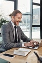 cheerful manager in formal wear typing