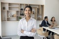 Cheerful manager girl posing with arms folded in office