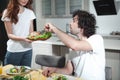 Cheerful married couple eating tasty foot at home