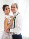 Cheerful married couple in white room