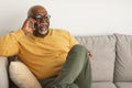 Cheerful Mature Black Man Chatting On Cellphone Sitting At Home Royalty Free Stock Photo