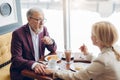 Cheerful mature couple having breakfast at cafe while chatting Royalty Free Stock Photo